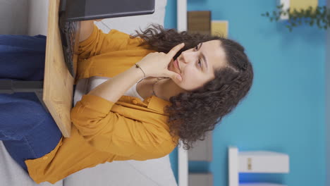 Vertical-video-of-Concentrated-young-woman-working-on-laptop.